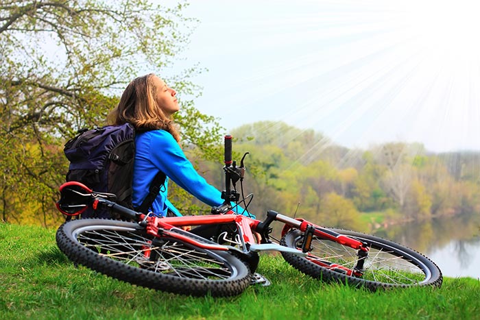 Frau mit Fahrrad auf Grünfläche